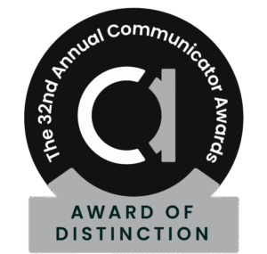 Black. white, and grey circle badge for the 32nd Communicator Awards, Award of Distinction